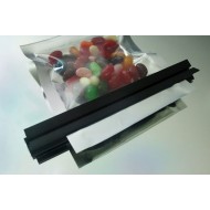 Black industrial heatless sealing clips holding flexible film pouch full of candy closed