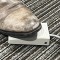 foot pedal in use by foot in boot 
