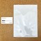 7.25 x 9.5 White MylarFoil Pouch next to business card