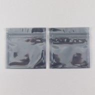 two small zip pouches laying on table showing slight gray transparency