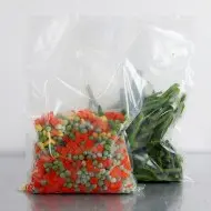 two high barrier QX pouches with green and yellow beads in left pouch and purple beads in right pouch