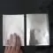 hand entering open end of clear silver medical pouch