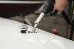 gas pump being inserted into car