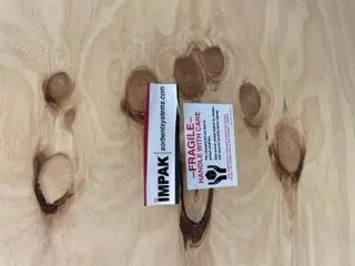 Impak logo next to fragile sticker on crate